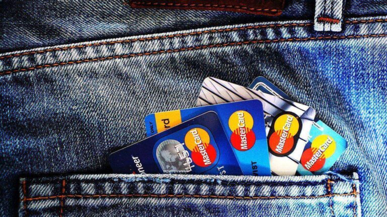 Credit cards in a jeans pocket. Featured image for Kim Monson Newsroom: Credit card rate cap could cut off 80 percent of cardholders